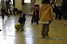 小さな子がサッカーボールで遊んでいる写真です。