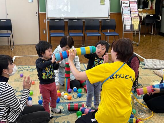 筒で遊んでいる写真
