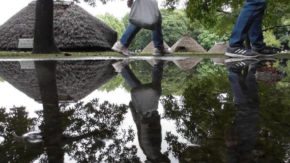 水子貝塚公園　10月　雨降りの貝塚公園で多くの人が散歩していました。背景の竪穴住居が印象的でした。（古舘澄夫さん（市内在住）撮影）