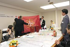 シャバツ市と富士見市の友好の旗を披露する訪問団の方
